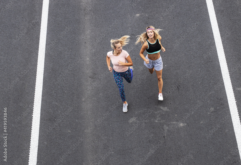 Two young females jogging at the city street.High angle view.
