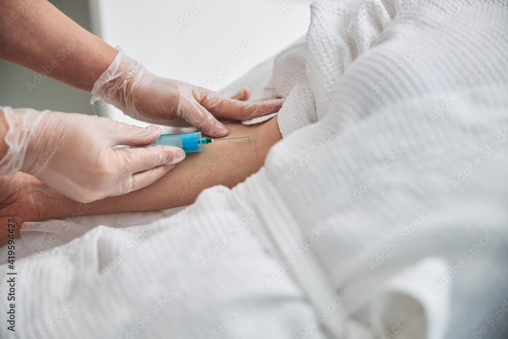 Female doctor making injection in patient arm Female doctor making injection in patient arm