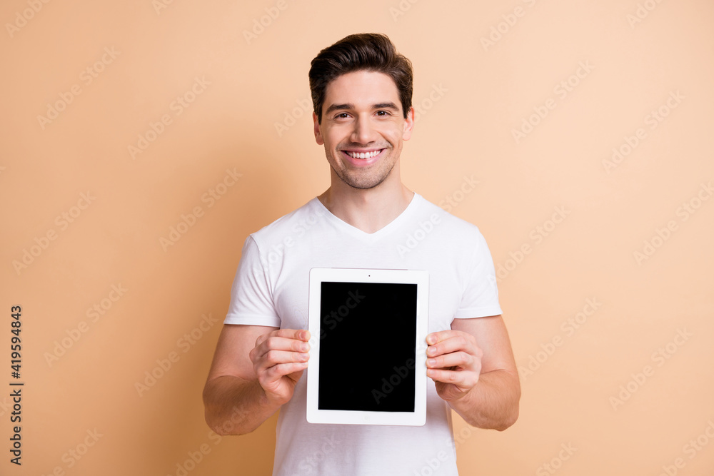 Photo of satisfied young person smile hands holding tablet show display isolated on beige color background
