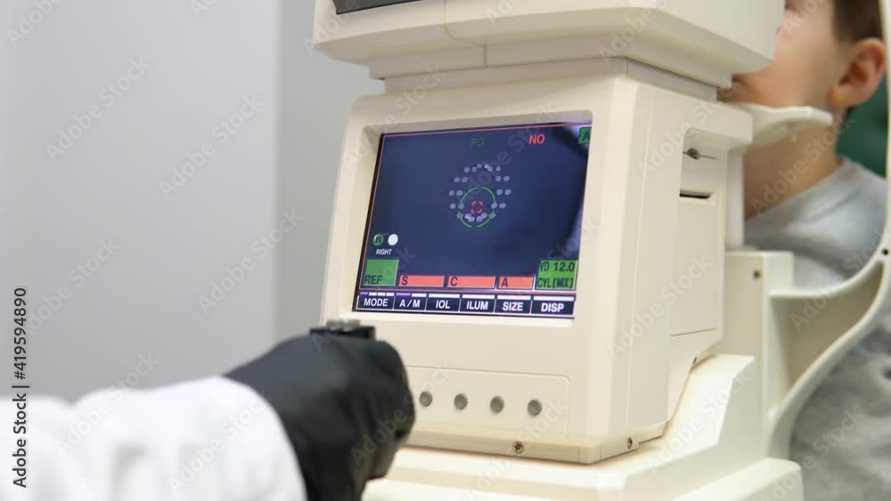A boy in an ophthalmology clinic performs a vision test on special equipment A boy in an ophthalmology clinic performs a vision test on special equipment