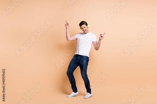 Full size photo of carefree guy closed eyes direct fingers up open mouth isolate don beige color background