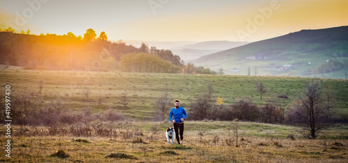 trail runner and his dog running photo