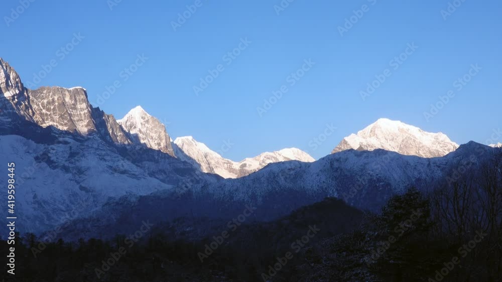 A view of the majestic Himalaya Mountains in the early morning light with a slight fog and haze in the foreground. A view of the majestic Himalaya Mountains in the early morning light with a slight fog and haze in the foreground.