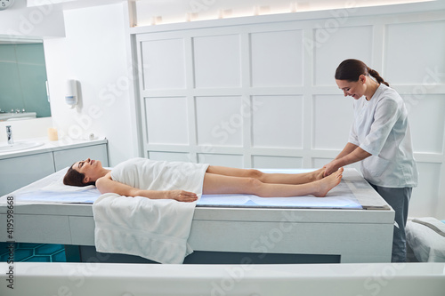 Beautiful woman receiving foot massage in spa salon