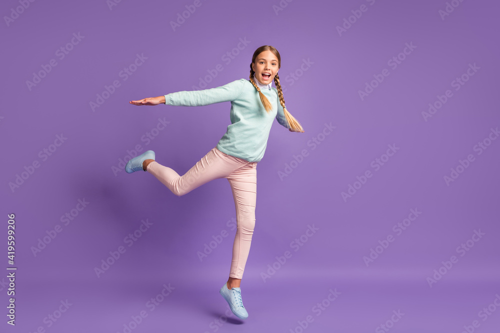 Photo portrait full body view of excited girl with spread arms jumping up isolated on vivid purple colored background