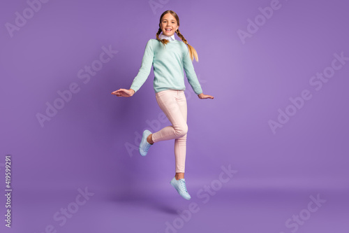 Photo portrait full body view of girl jumping up isolated on vivid purple colored background