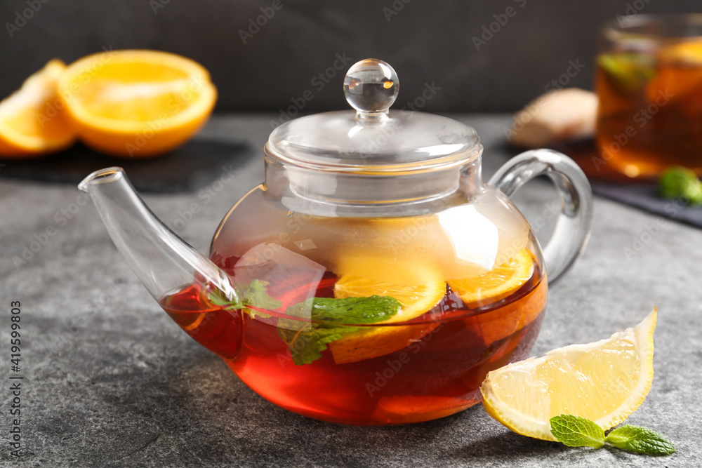 Hot tea with lemon slices and mint on grey table Hot tea with lemon slices and mint on grey table