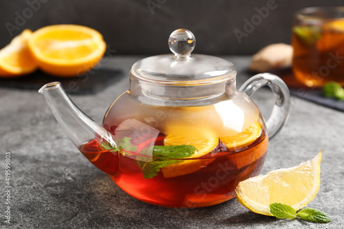 Hot tea with lemon slices and mint on grey table