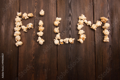 popcorn laid out word movie on wooden background snack