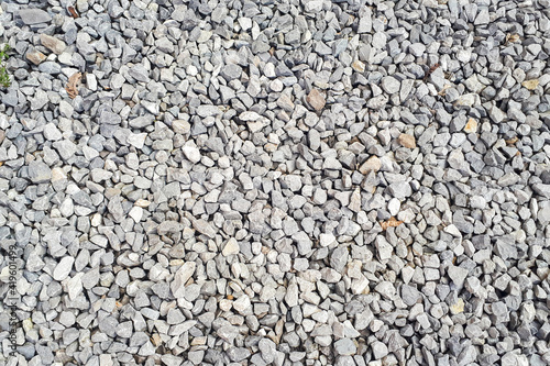 Gravel texture. Pebble stone background. Light grey closeup small rocks. Top