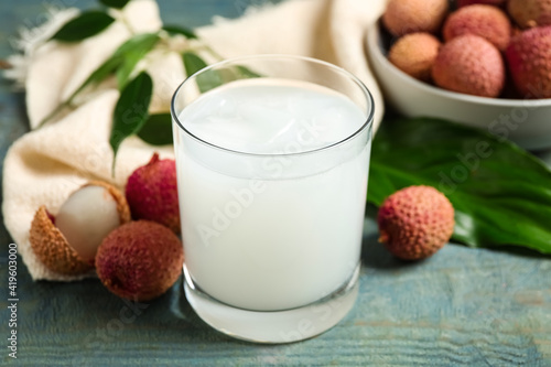 Fresh lychee juice and fruits on blue wooden table
