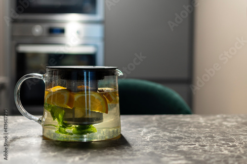 White tea in a glass teapot. Fruits in a glass teapot.Green mint and fruits. 