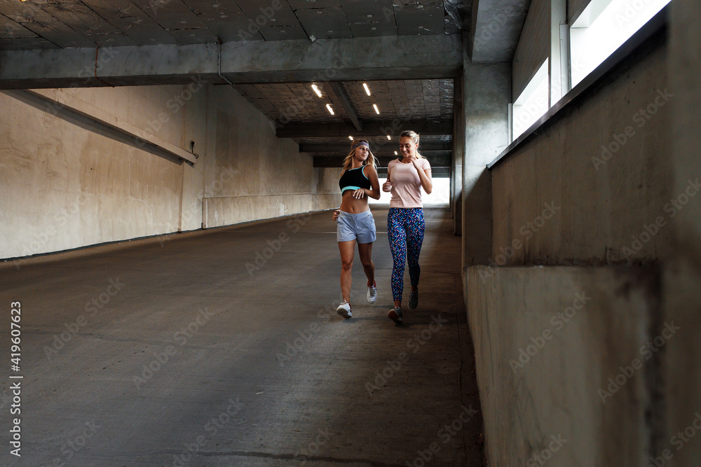 Two young female running and workout at the city street.They runs under the overpass. Two young female running and workout at the city street.They runs under the overpass.