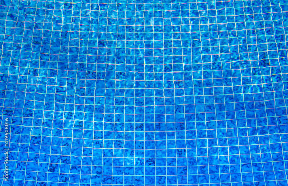 Blue Tile Lining of a swimming pool. Concept of evoke Vacation, sunshine and refreshment. Used for background or wallpaper Blue Tile Lining of a swimming pool. Concept of evoke Vacation, sunshine and refreshment. Used for background or wallpaper