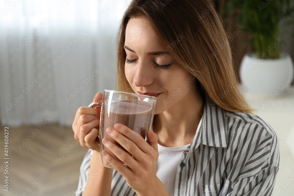 Young woman drinking chocolate milk in room Young woman drinking chocolate milk in room