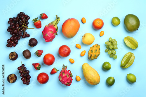 Many different delicious exotic fruits on light blue background, flat lay