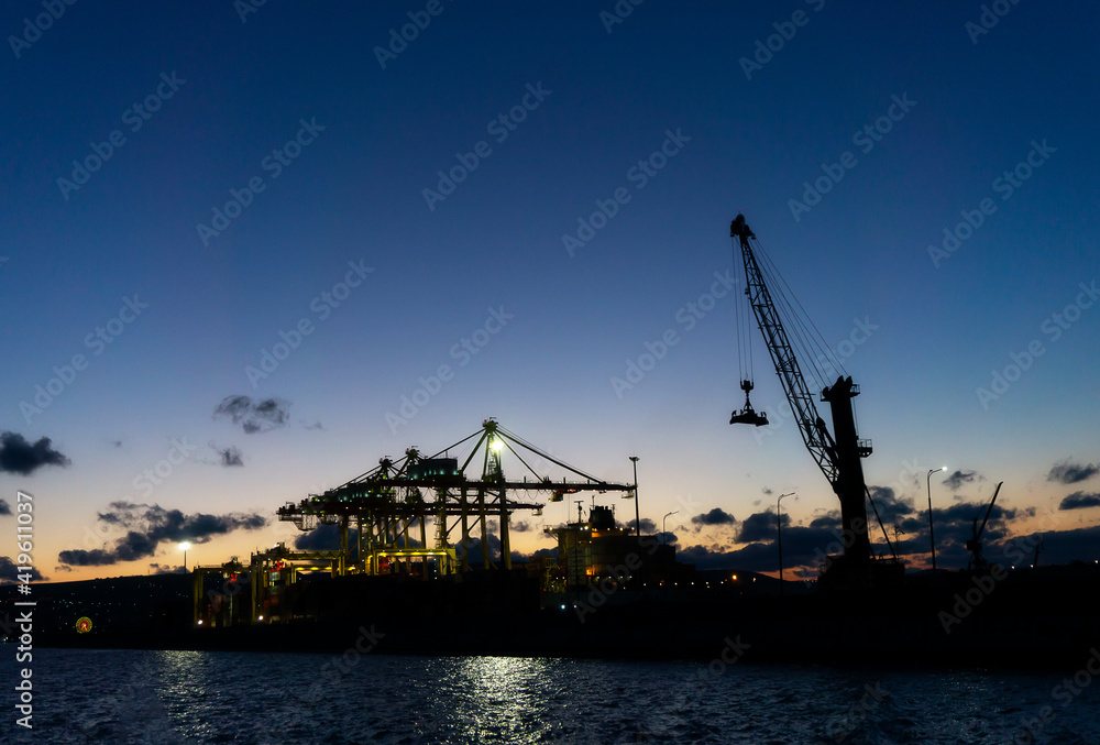 02 March 2021 Russia, Novorossiysk. International trade port with a crane for sea containers in the evening.