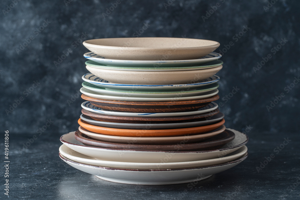Many empty plate on black background, close up Many empty plate on black background, close up