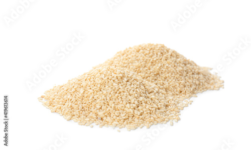 Piles of sesame seeds on white background