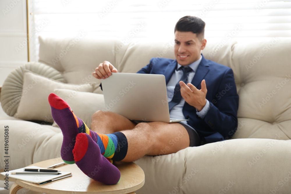 Businessman in jacket and underwear having video call at home, focus on legs Businessman in jacket and underwear having video call at home, focus on legs