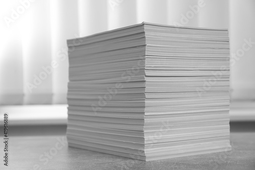 Stack of paper sheets on grey table