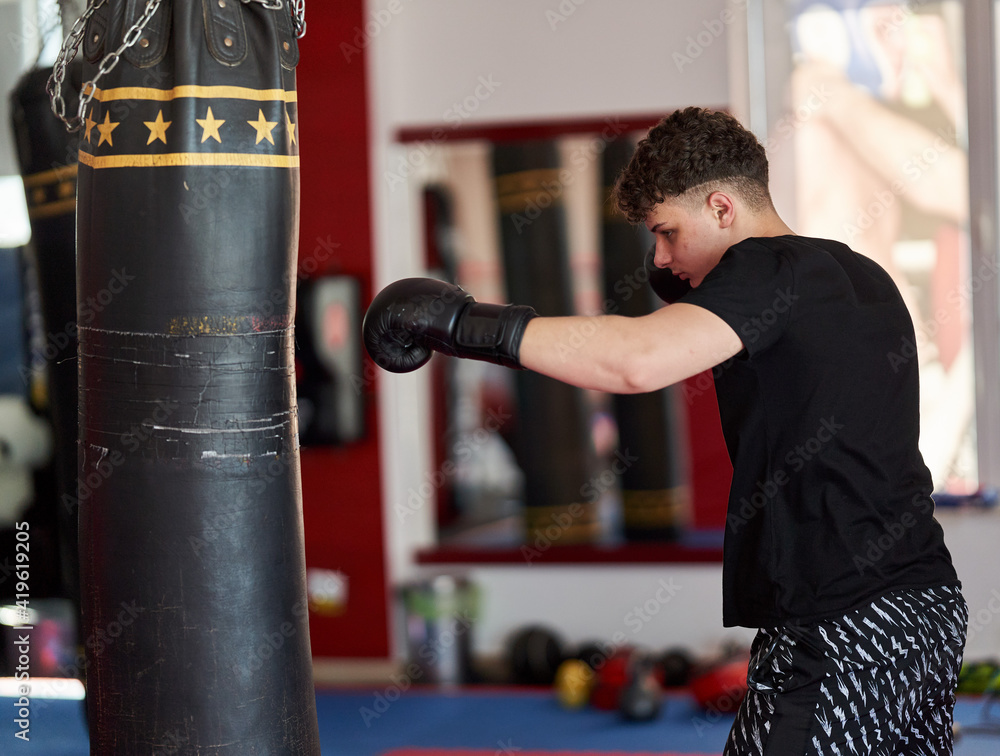 Young kickboxer hitting the heavy bag