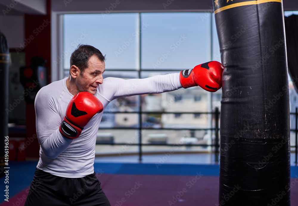 Kickboxer hitting the heavy bag in the gym