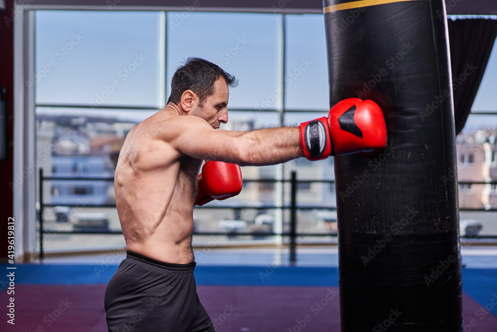 Kickboxer hitting the heavy bag in the gym