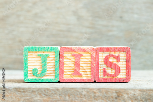 Color alphabet letter block in word JIS (abbreviation of Just in sequence) on wood background photo