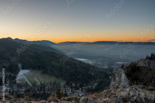 Panoramic view of sunset over Tatra Mountains, Zakopane town and Podhale region. The view from Nosal Peak. Selective focus on the ridge, blurred background.