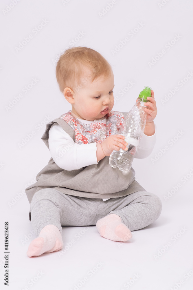 Baby girl learns to drink water from a bottle Baby girl learns to drink water from a bottle
