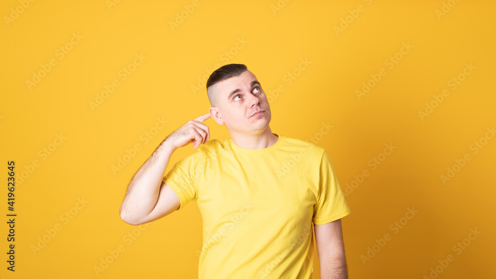 Young handsome man wearing casual t-shirt standing over yellow background confuse and wonder about question. Uncertain with doubt, thinking with hand on head. Pensive concept. Young handsome man wearing casual t-shirt standing over yellow background confuse and wonder about question. Uncertain with doubt, thinking with hand on head. Pensive concept.