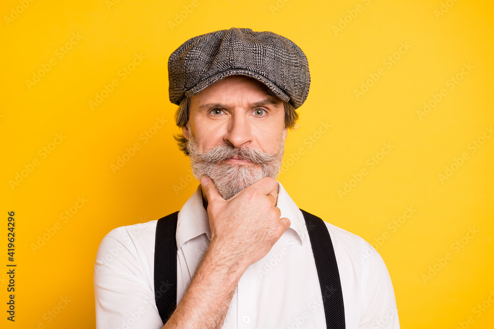Photo of aged man hand touch beard serious think thoughtful ponder isolated over yellow color background Photo of aged man hand touch beard serious think thoughtful ponder isolated over yellow color background