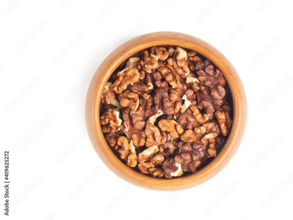 Obraz premium Shelled walnuts in wooden bowl on white