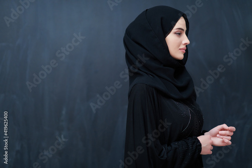 Modern young muslim woman in black abaya photo