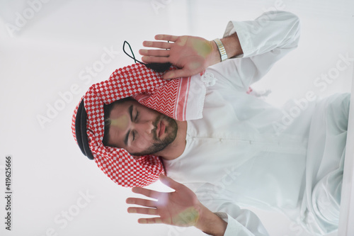 Muslim man doing sujud or sajdah on the glass floor photo