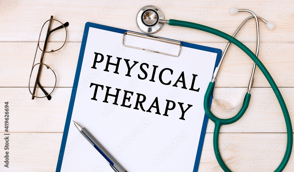 Paper with PHYSICAL THERAPY on a table, stethoscope and glasses Paper with PHYSICAL THERAPY on a table, stethoscope and glasses