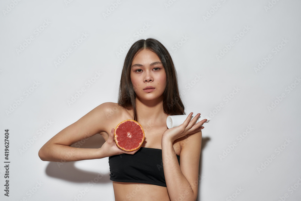 Brunette standing in the studio with a fruit Brunette standing in the studio with a fruit