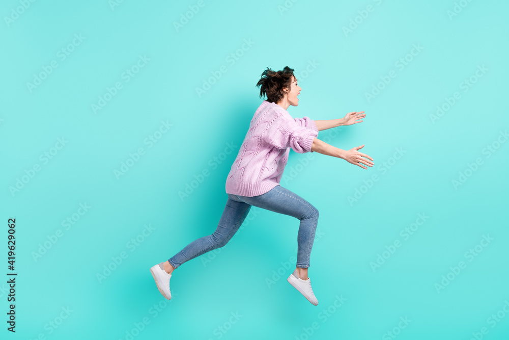 Full length photo of cute pretty woman running jumping looking empty space open arms isolated turquoise color background