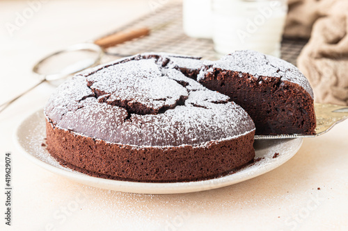 Fotografia, Obraz Chocolate sponge flourless cake with sugar powder, light concrete background