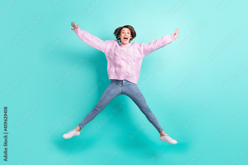 Full length photo of funny charming young woman wear violet sweater jumping like star isolated turquoise color background