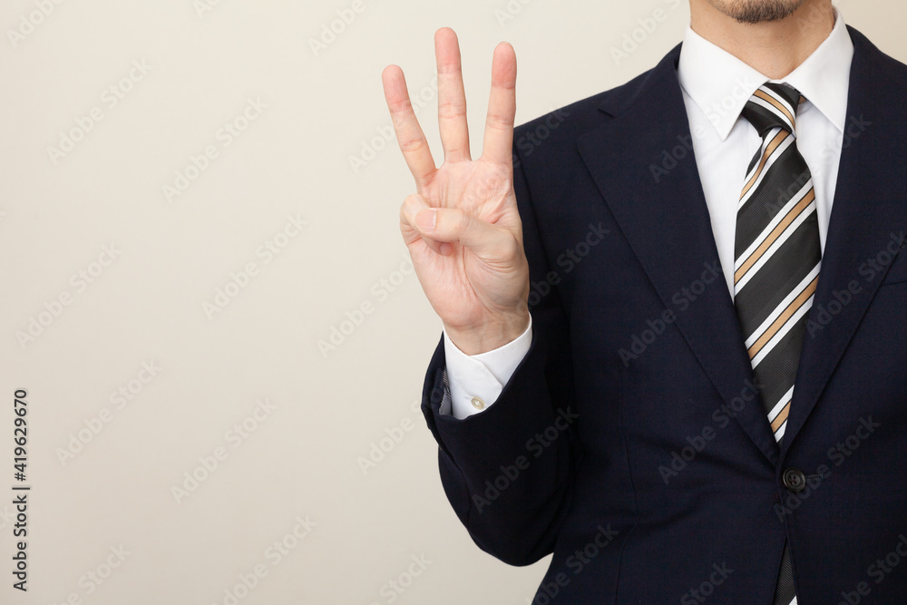 3本の指を立てるスーツを着た男性 Stock Photo Adobe Stock
