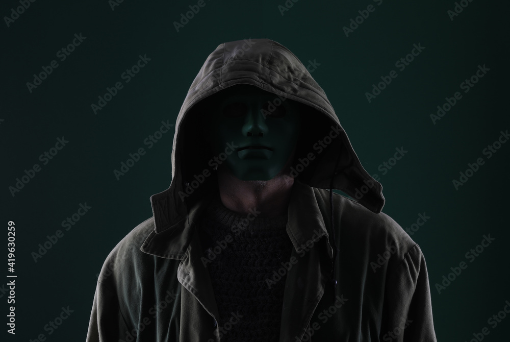 dark portrait of a hidden person on a green background dark portrait of a hidden person on a green background