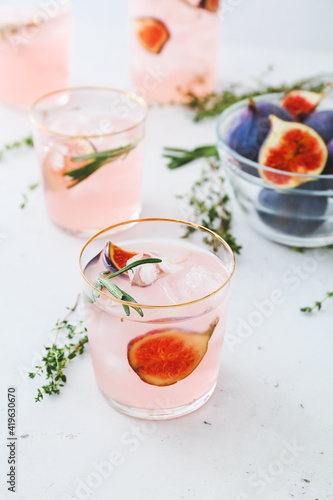 Glasses of tasty fig lemonade on light background