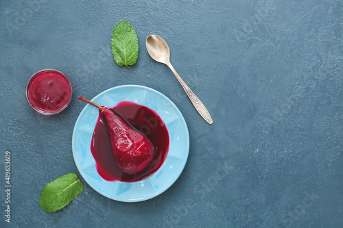 Cuadro en lienzo Plate of tasty poached pears in wine sauce on color background