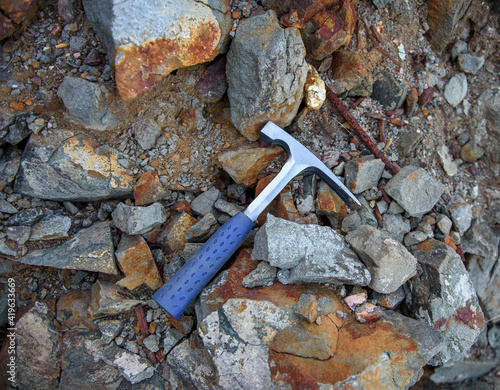 Obraz na płótnie Steel chisel edge rock pick, geologist tool over natural rocks background
