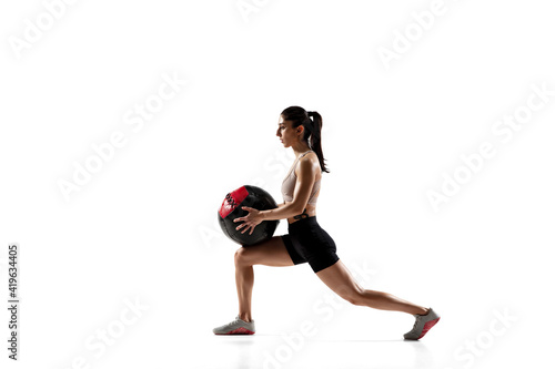 Ball practice. Caucasian professional female athlete training isolated on white studio background. Muscular  sportive woman. Concept of action  motion  youth  healthy lifestyle. Copyspace for ad.