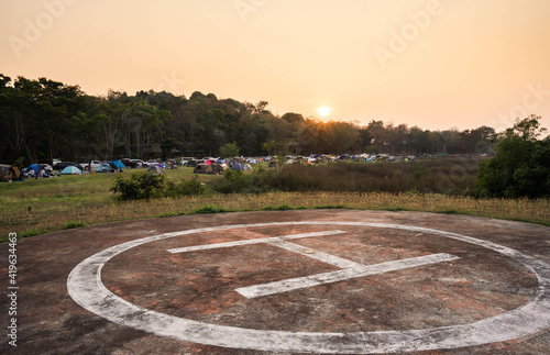 Phetchaburi, Thailand – February 26, 2021:  Helicopter landing area and tents of many tourists, sunrise in the morning. © black_J
