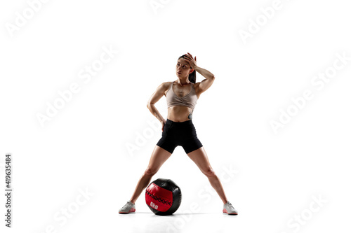 Powerful. Caucasian professional female athlete training isolated on white studio background. Muscular, sportive woman. Concept of action, motion, youth, healthy lifestyle. Copyspace for ad.