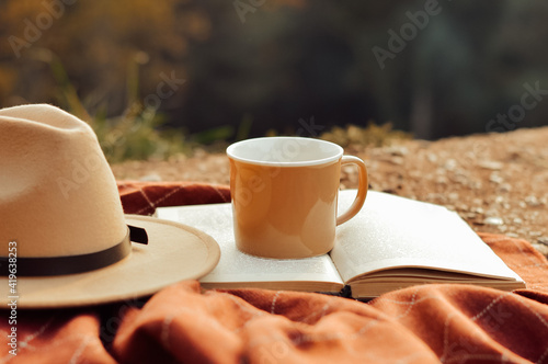 composition with mug, book and hat in nature